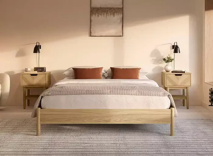 Serene bedroom with terracotta pillows in soft morning light, after enhancement.